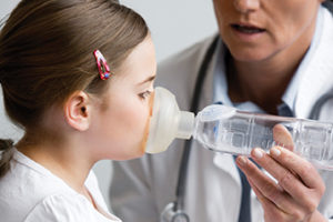 Doctor testing girl for asthma
