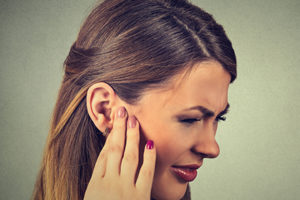 sick young woman having ear pain