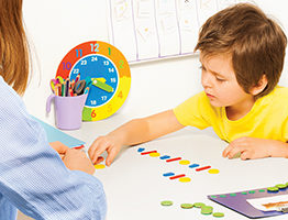 Concentrated boy putts colorful coins during ABA