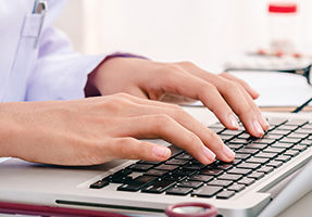 doctor typing on computer
