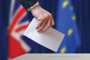 Election or referendum in Great Britain. Voter holds envelope.
