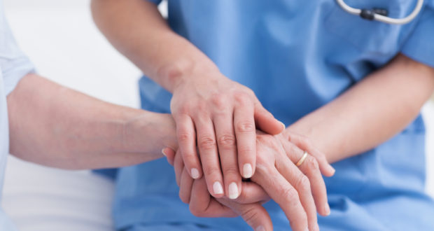 Close up of a nurse touching hand of a patient