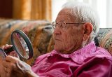 Elderly man looking at object with magnifier