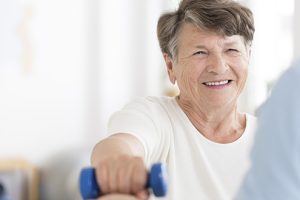 Happy senior woman exercising arms
